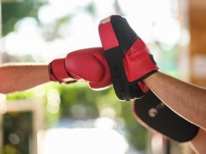 Red boxing gloved fist hitting a pad