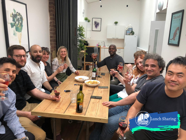 People sitting around a kitchen table at Mainyard Studios Wimbledon South