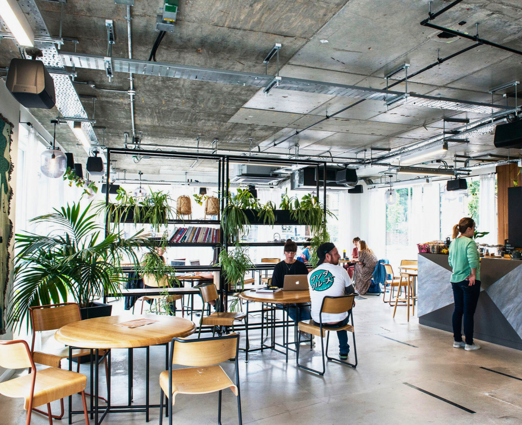 Creative professionals working in a London coworking space with laptop and coffee